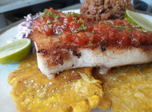 Una foto de Filete de róbalo con patacones y ahogado al estilo caribeño