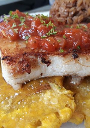 Una foto de Filete de róbalo con patacones y ahogado al estilo caribeño
