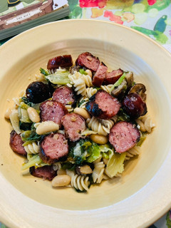 A picture of Smoked Chicken sausage, Escarole and beans over quinoa and brown rice pasta.