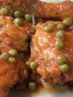 Una foto de Pollo con salsa de tomate y guisantes