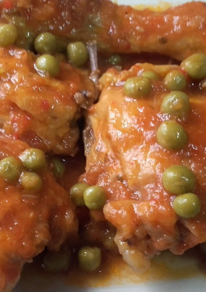 Una foto de Pollo con salsa de tomate y guisantes