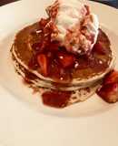 Pancakes loaded with whipped cream and strawberries