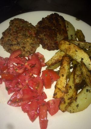 Una foto de Hamburguesa de lenteja con papas y tomates