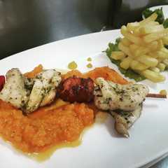 Una foto de Brocheta mixta sobre poteca de ahuyama y torre de francesa