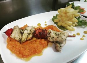 Una foto de Brocheta mixta sobre poteca de ahuyama y torre de francesa