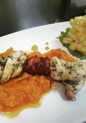 Una foto de Brocheta mixta sobre poteca de ahuyama y torre de francesa