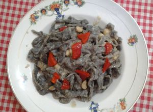 Una foto de Tagliatelle en tinta de calamar con salsa mollica