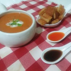 A picture of Tomato carrot soup with croutons.