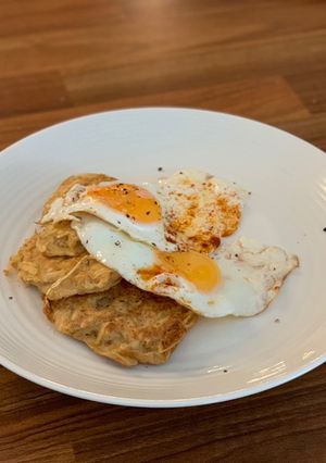 A picture of Potato hash browns with fried eggs.