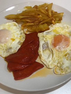 Una foto de Huevos fritos con pimientos del piquillo y patatas fritas