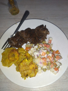 Una foto de Carne de res al vino tinto, acompañado de patacones y ensalada