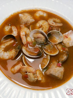 Una foto de Sopa de almejas y gambas, con fondo de merluza