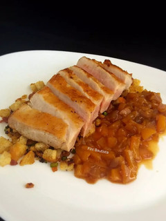 Una foto de Secreto de cerdo con migas de pan y chutney de melocotón
