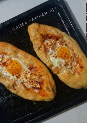 A picture of Egg top chicken stuffed pide bread(turkish pide).