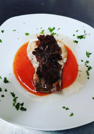 Una foto de Merluza con cremoso de patata y sofrito de jamón y módena