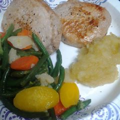A picture of Brady Bunch pork chops and homemade apple sauce.