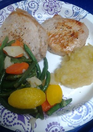 A picture of Brady Bunch pork chops and homemade apple sauce.