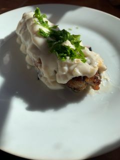 Una foto de Rollitos de cecina rellenos acompañados de salsa bechamel