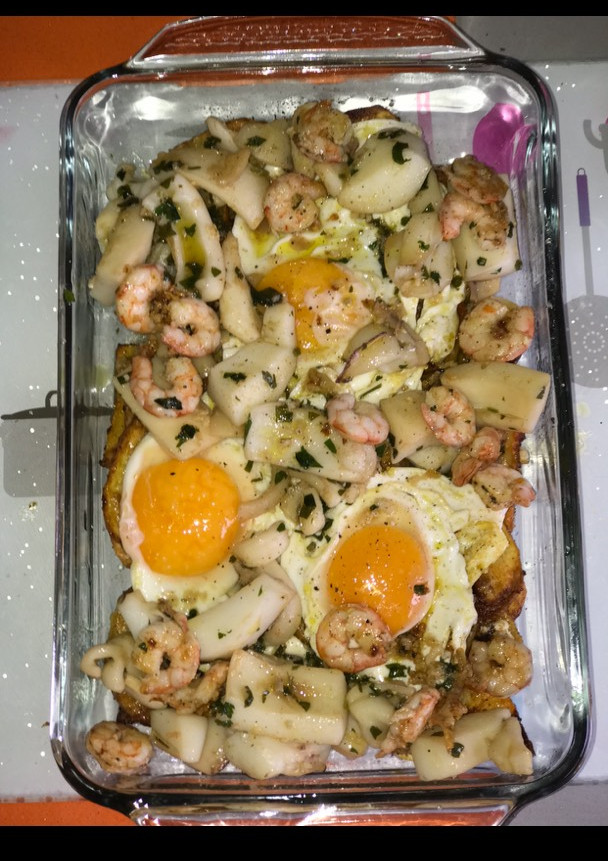 Una foto de Huevos estrellados con sepia y gambas