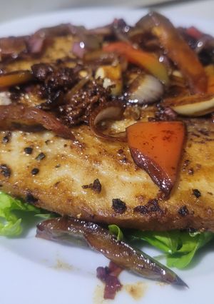 Una foto de Filete de pescado salteado con pimiento, sobre lecho de tomato y lechuga