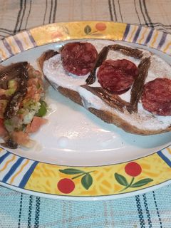Una foto de Tostada de pan de pueblo con queso Kéfir, salchichón ibérico y anchoas