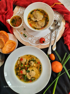 A picture of Orange flavour sweet & sour soup with besan ravioli.