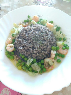 Una foto de Arroz negro con gambas y guisantes