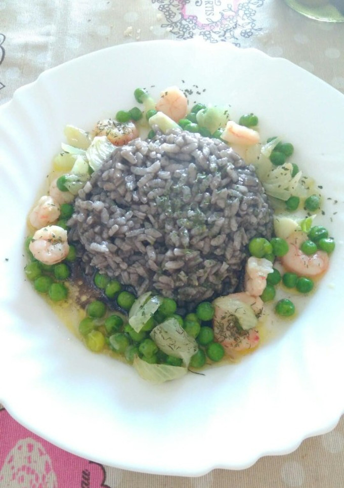 Una foto de Arroz negro con gambas y guisantes
