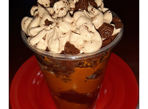 Una foto de Torta en vaso de brownie manjar y frosting de chocolate