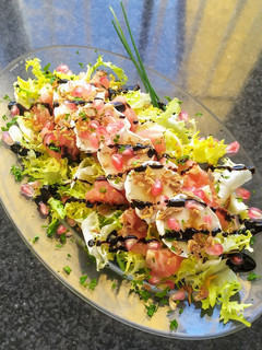 Una foto de Ensalada de escarola, rulo de cabra y Granada
