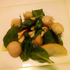 A picture of Spinach and scallop salad with apple and pine nuts.