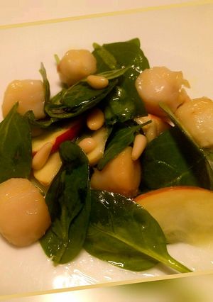 A picture of Spinach and scallop salad with apple and pine nuts.