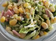Una foto de ensalada de jamón y maíz