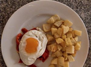 Una foto de Patatas fritas en cubo con huevo y pimientos