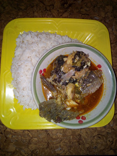 A picture of White rice and yellow stew with fresh fish.