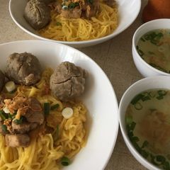 A picture of Egg noodle soup with meatballs.