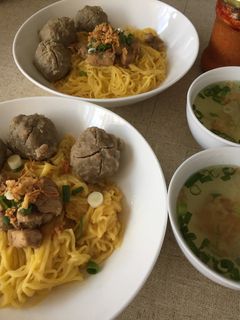A picture of Egg noodle soup with meatballs.