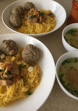 A picture of Egg noodle soup with meatballs.