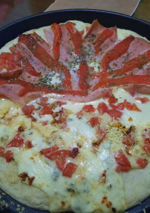 Una foto de Pizza mitad mantecoso, jamón y morrón, mitad con 3 quesos