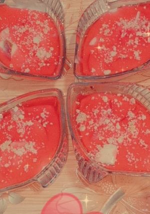 A picture of Jelly with strawberry chunks and almond topping.