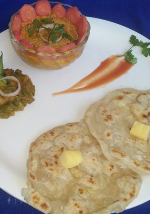 A picture of Navratna korma,potato beans veg with layered paratha.