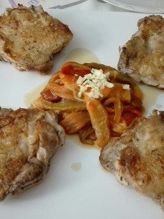 Una foto de Muslos de pollo con pimientos asados