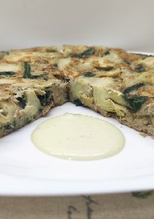 Una foto de Tortilla de alcachofas y espinacas con alioli de aguacate