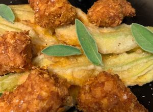 Foto di Pollo croccante al corn flakes con fiori di zucca in pastella e salsa alle ciliegie