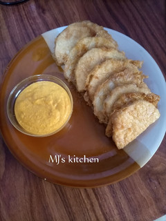 A picture of Fried yam coated with egg and spicy fry sauce.