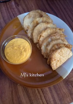 A picture of Fried yam coated with egg and spicy fry sauce.