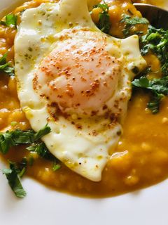 Una foto de Crema de arvejitas amarillas con zapallo camote y huevo frito