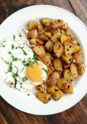 A picture of Fried potatoes and egg -breakfast.