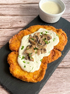 Una foto de Milanesa de pollo con champiñones y salsa de queso azul