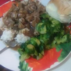 A picture of Pork Tips and Onions over White Rice.